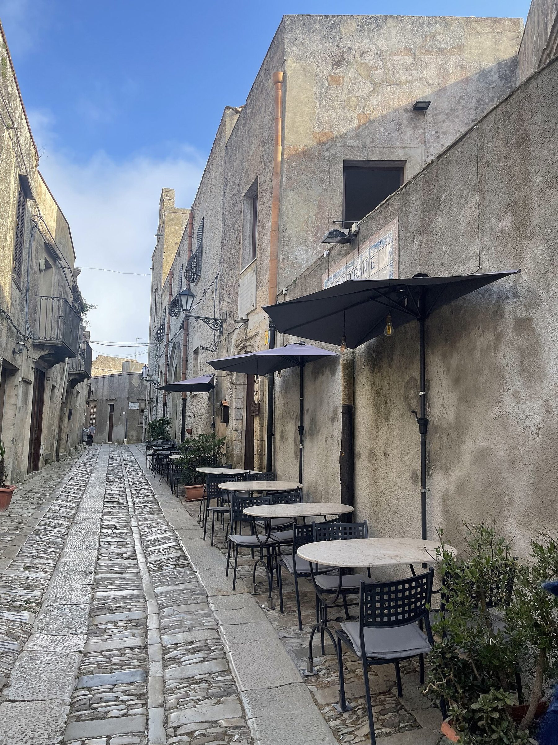 An open restaurant terrace in Erice in the late afternoon light.