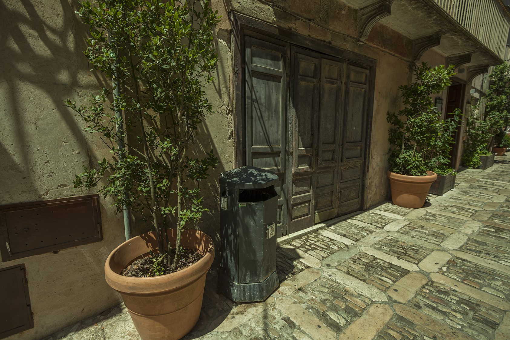 A narrow lane in Erice with a polished stone pavement and a Madonna shrine.
